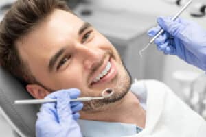 A man sitting in a dentist's chair and smiling